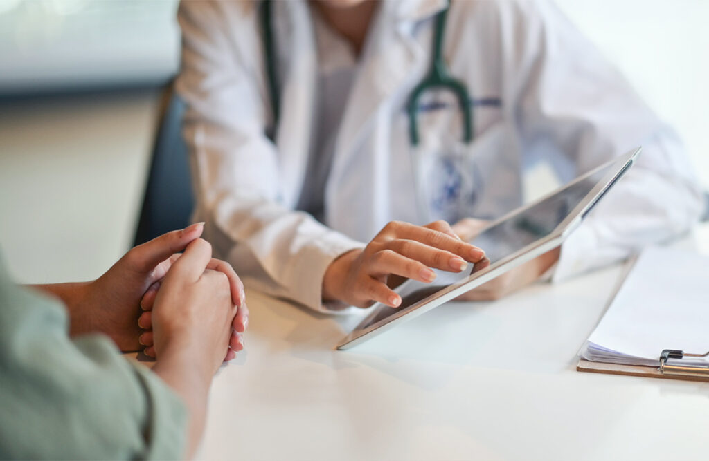 A physician shows goes over treatment plan on tablet