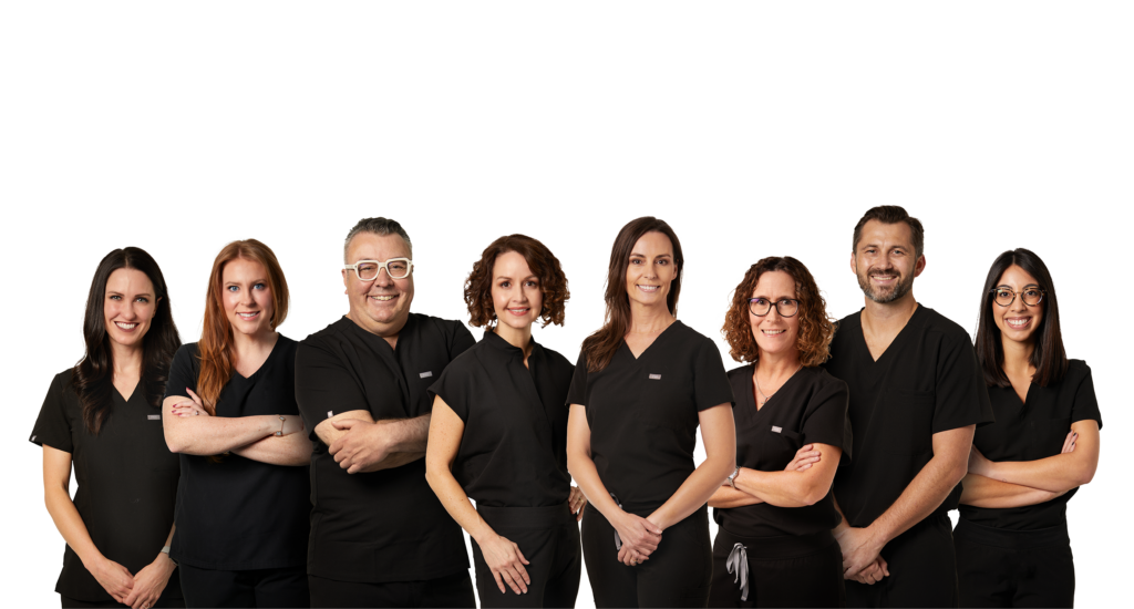 Eight Tulsa OB-GYN physicians in black scrubs pose for a group photo in front of a white backdrop